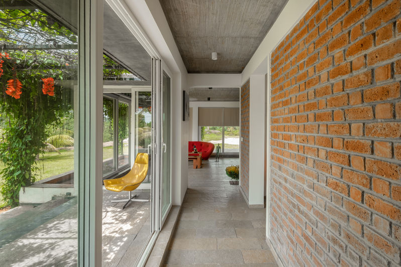 Red walled corridor of Poojika farmhouse Ramanagara Karnataka - Residential Architecture by Keystone Studio