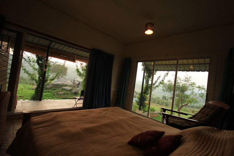 Bedroom with a view at Manchinabele Farmhouse - Residential Architecture by Keystone Studio Bengaluru