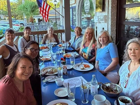 Friends gathered together at Wolf Island Oyster Co., enjoying a coastal dining experience with fresh seafood.