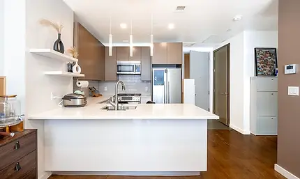 Open kitchen and living area in a 2-bedroom condo at 75 Wall Street #29C, New York City, listed by Acre NY Realty
