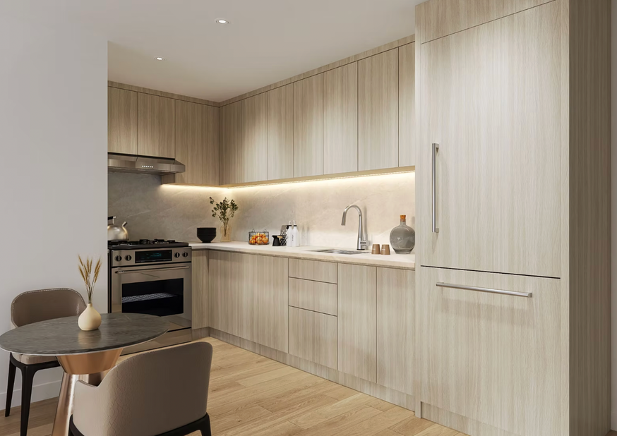 Modern kitchen at The Prince Flushing — light wood cabinetry, built-in appliances, and warm recessed lighting.