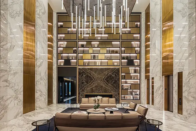 Double-height resident library and lounge at 125 Greenwich Street with architectural shelving