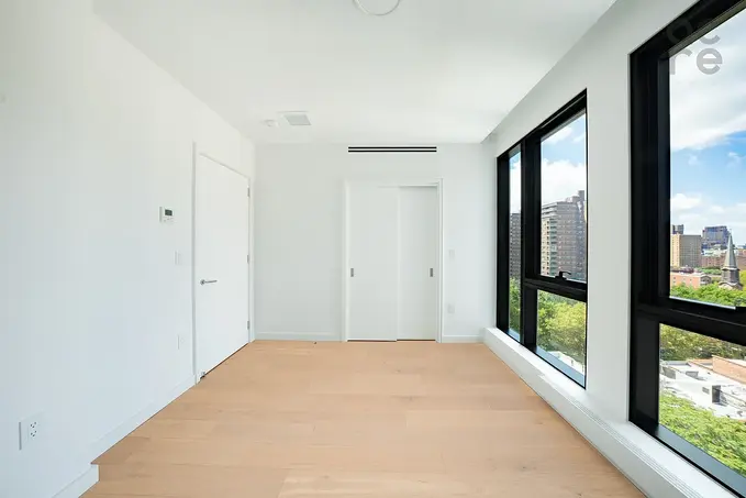 Bright bedroom with floor-to-ceiling windows and hardwood floors at 300 West 30th Street #12C
