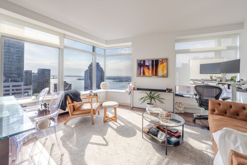 Open living and dining area at 123 Washington Street #33A with natural sunlight and skyline view in Manhattan