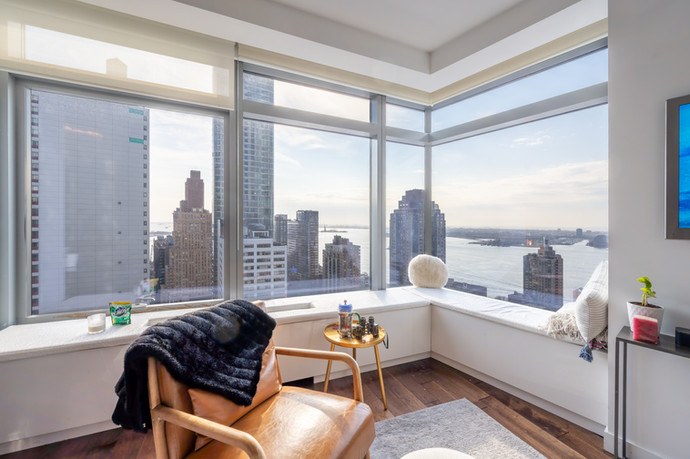 Living room of 123 Washington Street #33A, modern condo with floor-to-ceiling windows and city views in New York
