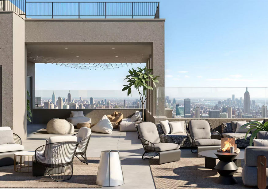 Open-sky rooftop terrace at The Parisian Astoria featuring a partially covered lounge, outdoor seating, fire pit, and unobstructed Manhattan skyline views.