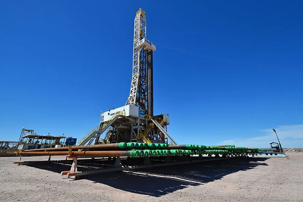 La foto de portada muestra una torre de perforación de pozos de petróleo en un desierto bajo un cielo azul brillante. En primer plano, hay filas ordenadas de tuberías de perforación apiladas en bastidores de metal. El sitio está en el desierto con equipos de soporte visibles a la izquierda y a la derecha.