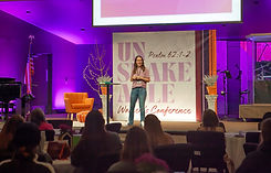 photo of a woman (Cassie Hart) speaking to a group of women