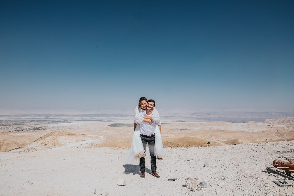 Oleh Sophie Knop on the back of her husband during their wedding photoshoot