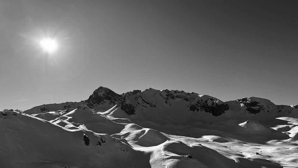 a black and white photo of snow covered mountains
