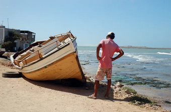 Fisherman looking at a boat on the ocean in Boa Vista