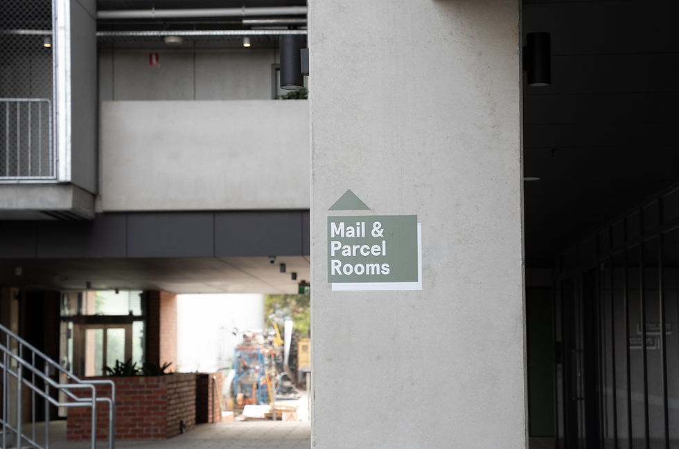 Mail and parcel room sign displayed inside a modern apartment building corridor