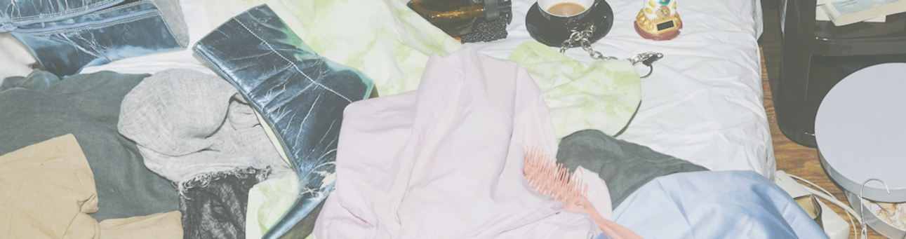 a messt bed full of fashion accessories and clothes