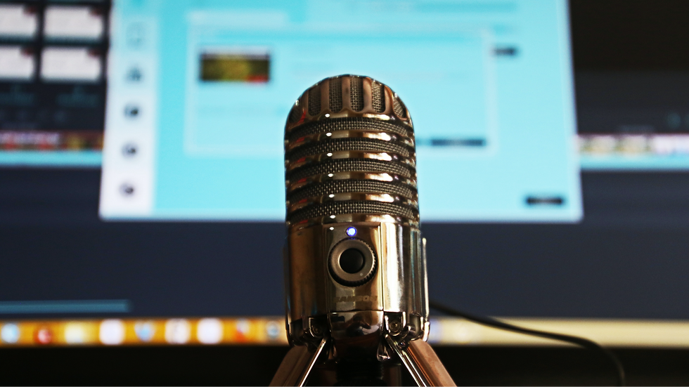 Microphone and computer monitor with video editing software open.