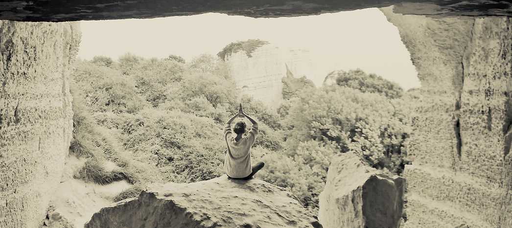 Leah sat meditating looking out over treetops from a cave