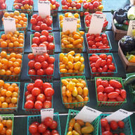 Various tomatoes in baskets. Fresh produce on display.