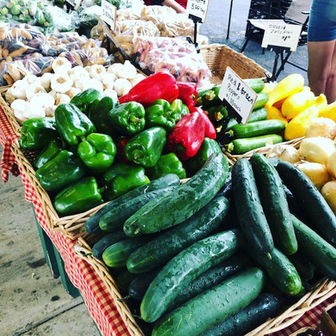 Fresh vegetables at a market, including cucumbers and peppers.
