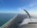 airplane in flight over coast /OBX Aviation