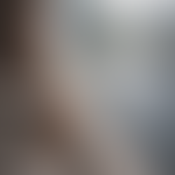 Frau schaut nachdenklich aus dem Fenster