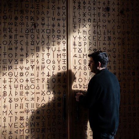 Ein Mann schaut auf eine große verschlossene Tür voller Muster Hieroglyphen und versucht diese zu entschlüsseln nur so öffnet sich die Tür.