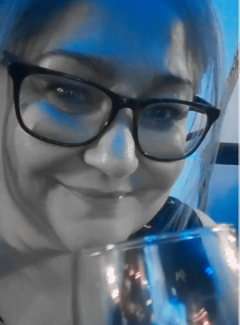 Smiling woman with glasses holding a drink