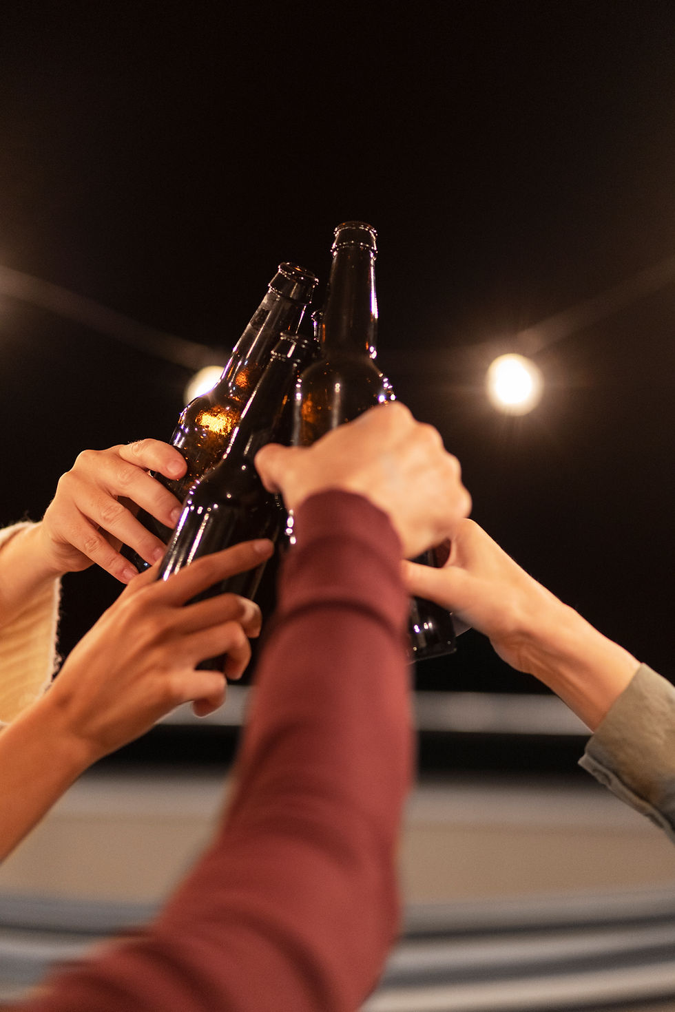 Friends toasting beer bottles at a Live House in Penang