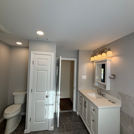 Full bathroom renovation with white vanity, medicine cabinet, slate tile flooring, and updated fixtures by Booth Home Impressions in South Jersey