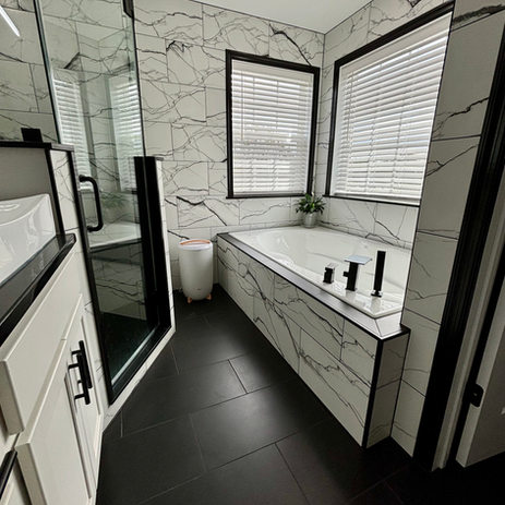 Master bathroom remodel with dramatic marble tile surround, built-in soaking tub, matte black fixtures, frameless glass shower, and dark slate floor tile in South Jersey
