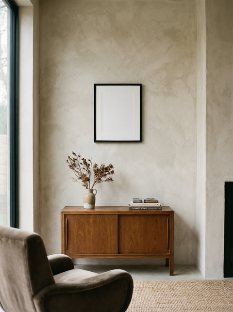 Arredamento di una stanza con mobile in legno, cornice e stampe fine art.