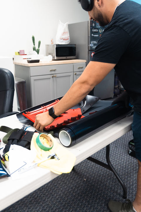 Technician cutting vinyl wrap material at Innovated Design in Temecula, CA