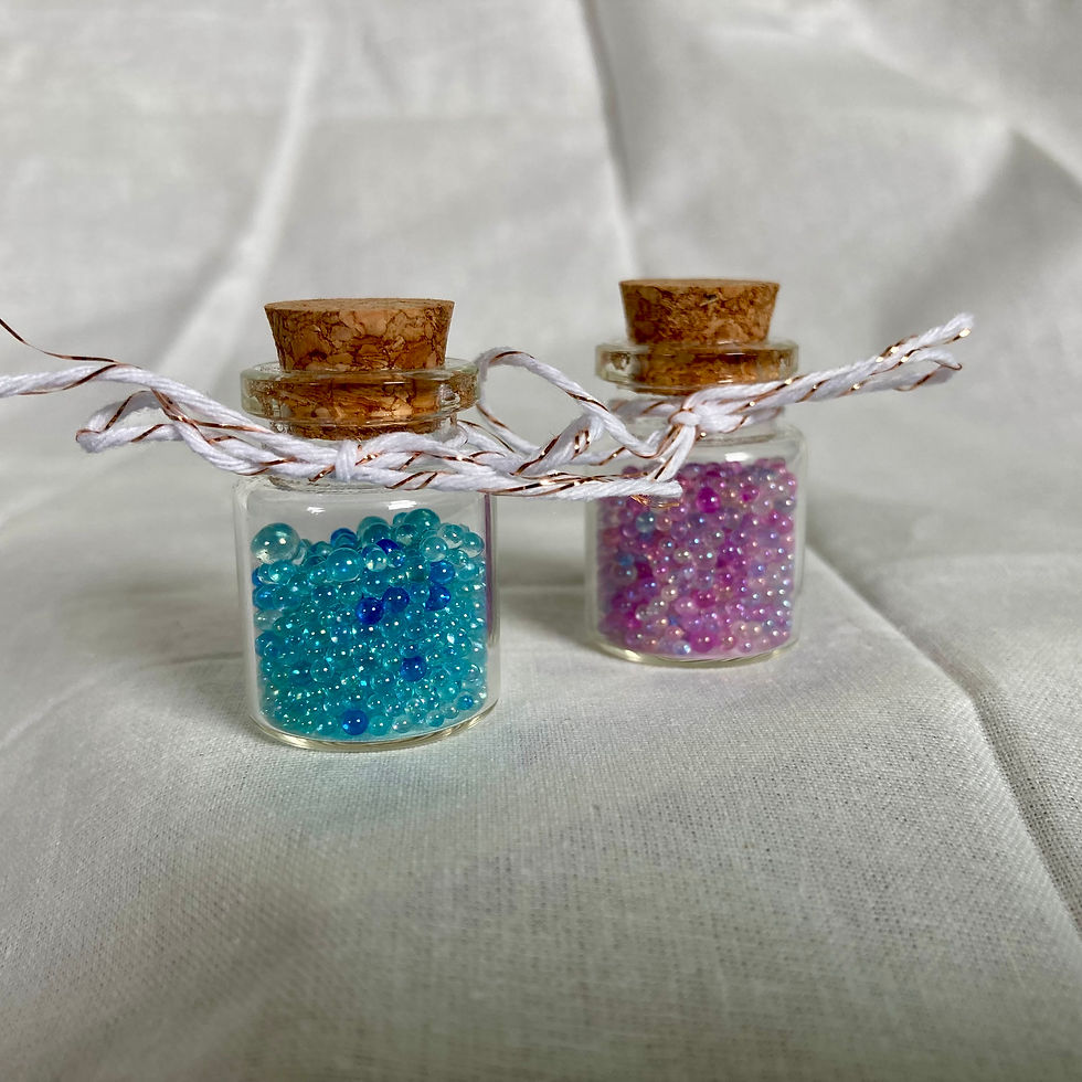 Two small glass jars filled with blue and pink "bubbles"