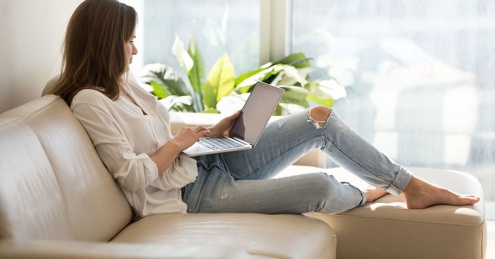 Woman on couch writing a support email to a customer—demonstrating how creating raving fans through support begins with thoughtful communication