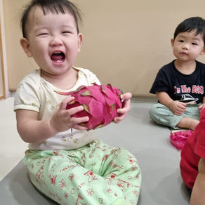 Happy toddler holding a dragon fruit.