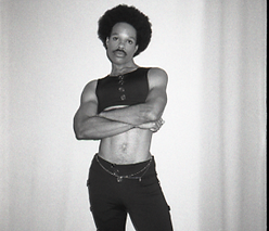 Model posing with arms crossed in black and white photo inspired by Prince "Parade" album shoot