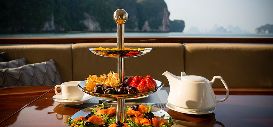 Afternoon tea with a three tiered snack server on a luxury motor yacht in Phang Nga Bay ne