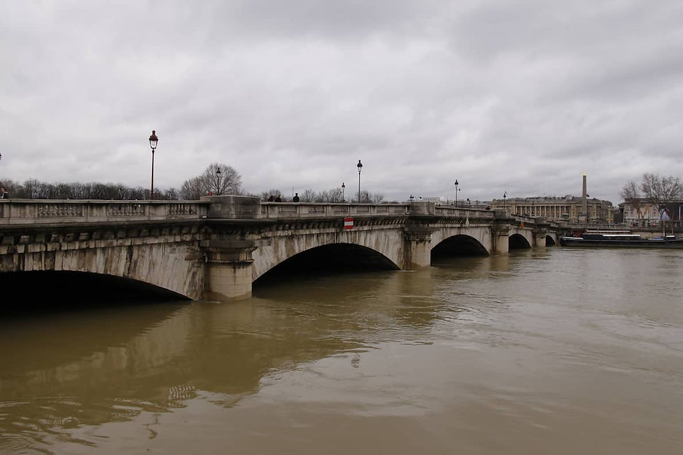 Le Pont de la Concorde à Paris pendant la crue de la Seine, avec l'eau marron qui monte dangereusement, ne laissant que peu d'espace sous les arches.