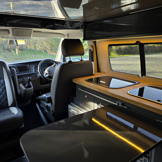 Inside camper, side table out with side lights on