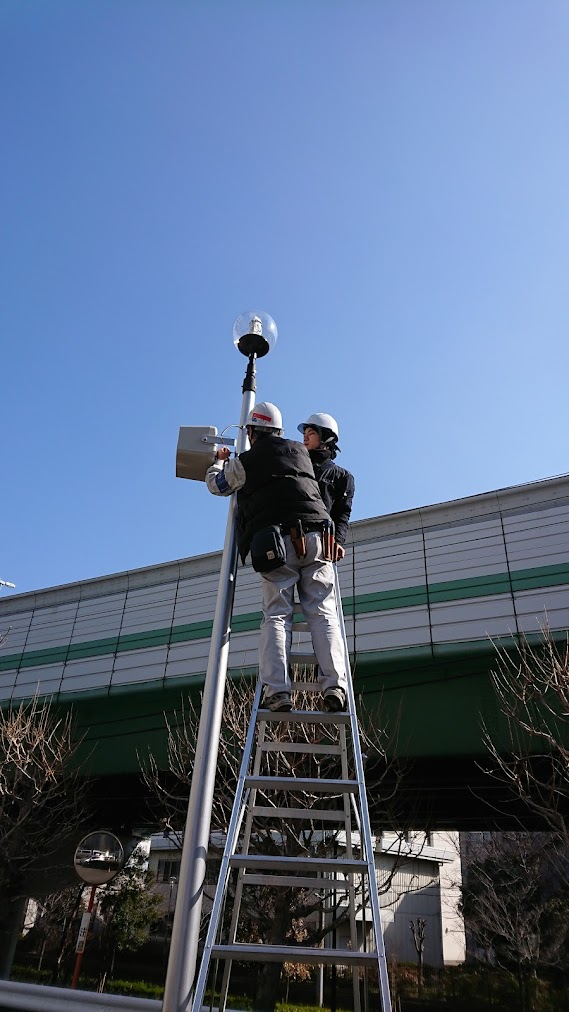集合住宅で防犯カメラを設置する作業風景