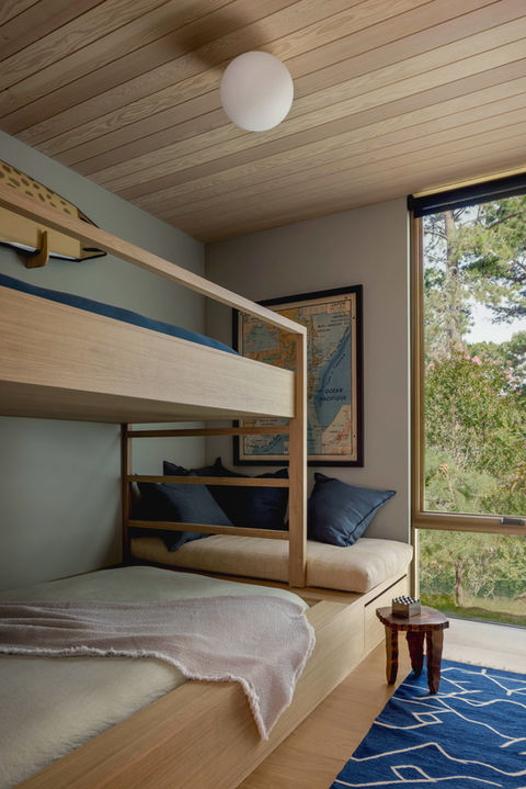 Hamptons Home Interior Design by Emily Lindberg Design. Guest / Kids Bedroom Custom Oak Bunk Bed. Pine Wood Clad Ceiling, Nautical Art, Full Height Window. Blend of Warm and Cool Natural Colors.
