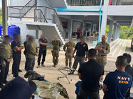 Military personnel listening to an instructor prior to beginning a training exercise.