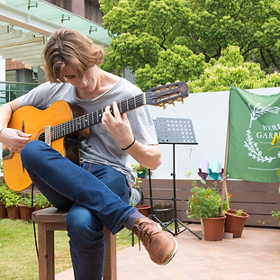 Student performing guitar at HKU Herb Garden