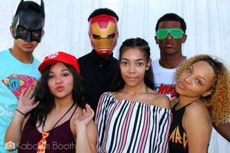 Young people in photo booth with superhero masks and shutter shades