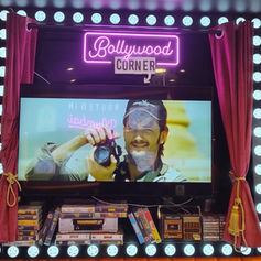 Bright pink neon sign framed beautifully above a large video display screen.