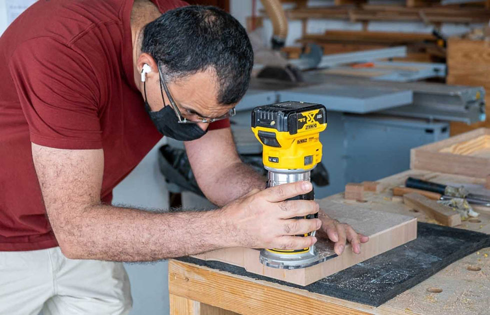 A participant trimming a cutting board with a router at The Makers Society