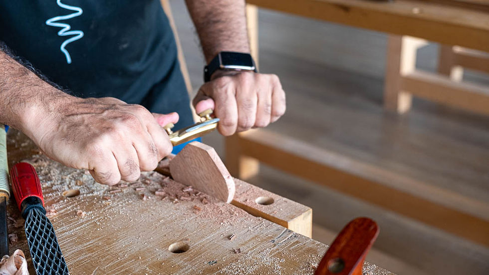 Close-up of a man shaping wood with a spokeshave at The Makers Society