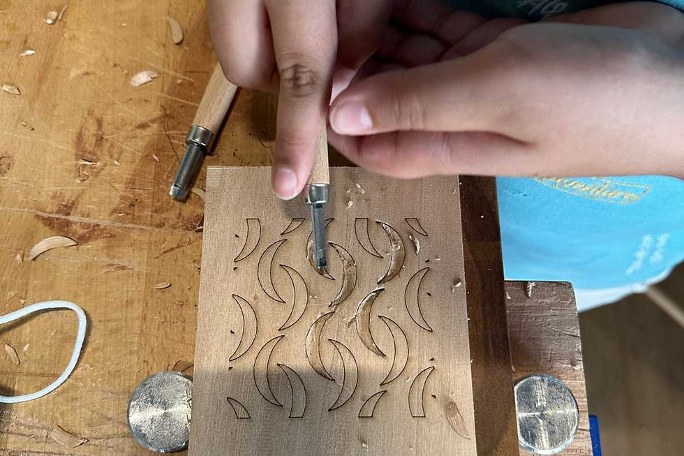 Child carving wood with hand tools during a kids woodworking class in Dubai.