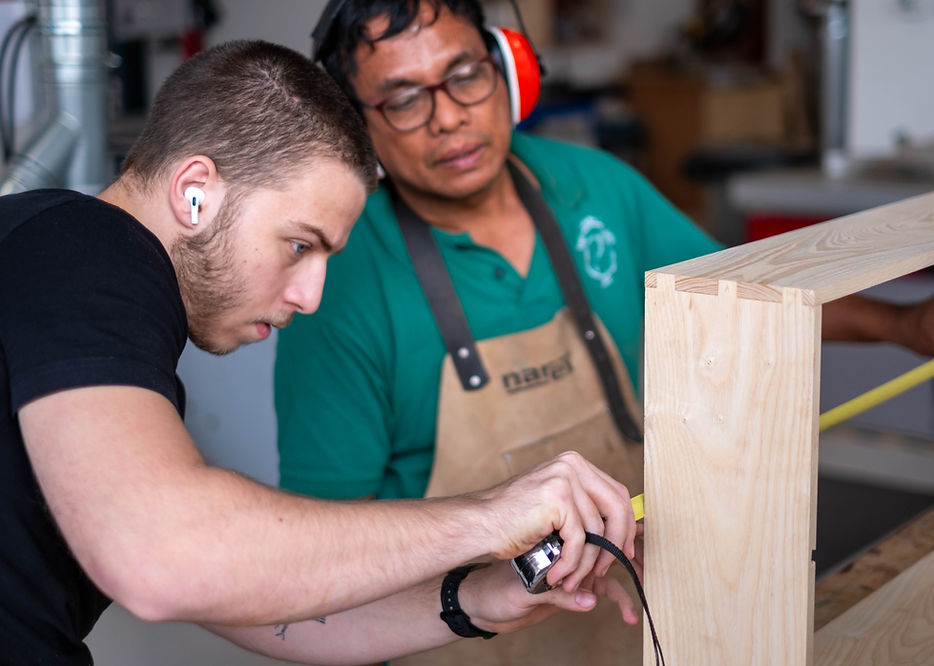 A member of The Makers Society is working on the construction of a drawer