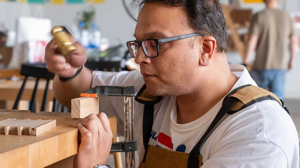 Man cutting dovetail joints by hand during a woodworking class at The Makers Society