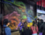 Guide leading a nighttime street art tour in Chapinero, Bogotá, in front of a large graffiti mural