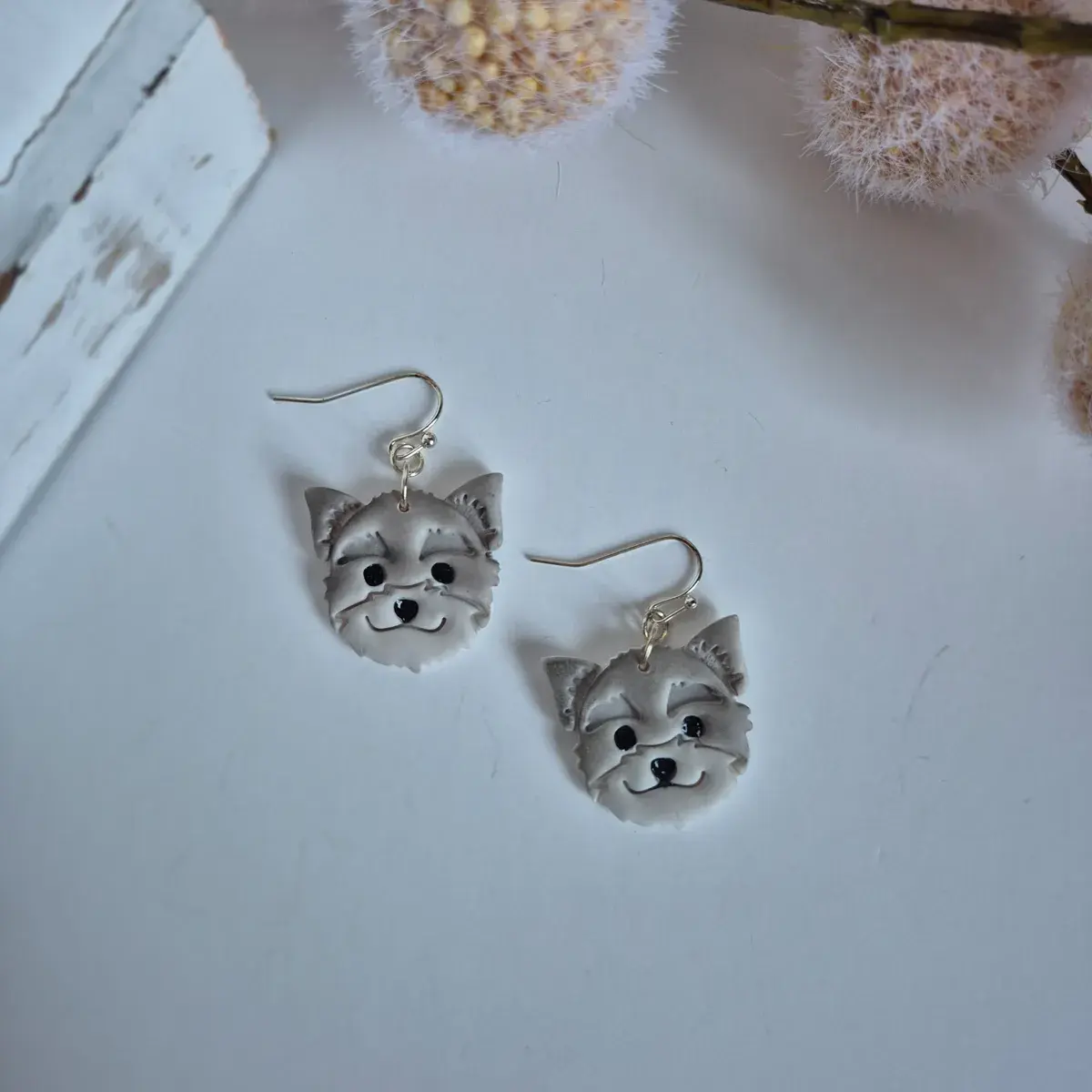 Handmade Old English Sheepdog earrings crafted from polymer clay with silver hooks, styled on white background